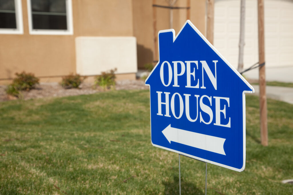 An open house sign in front of a house.