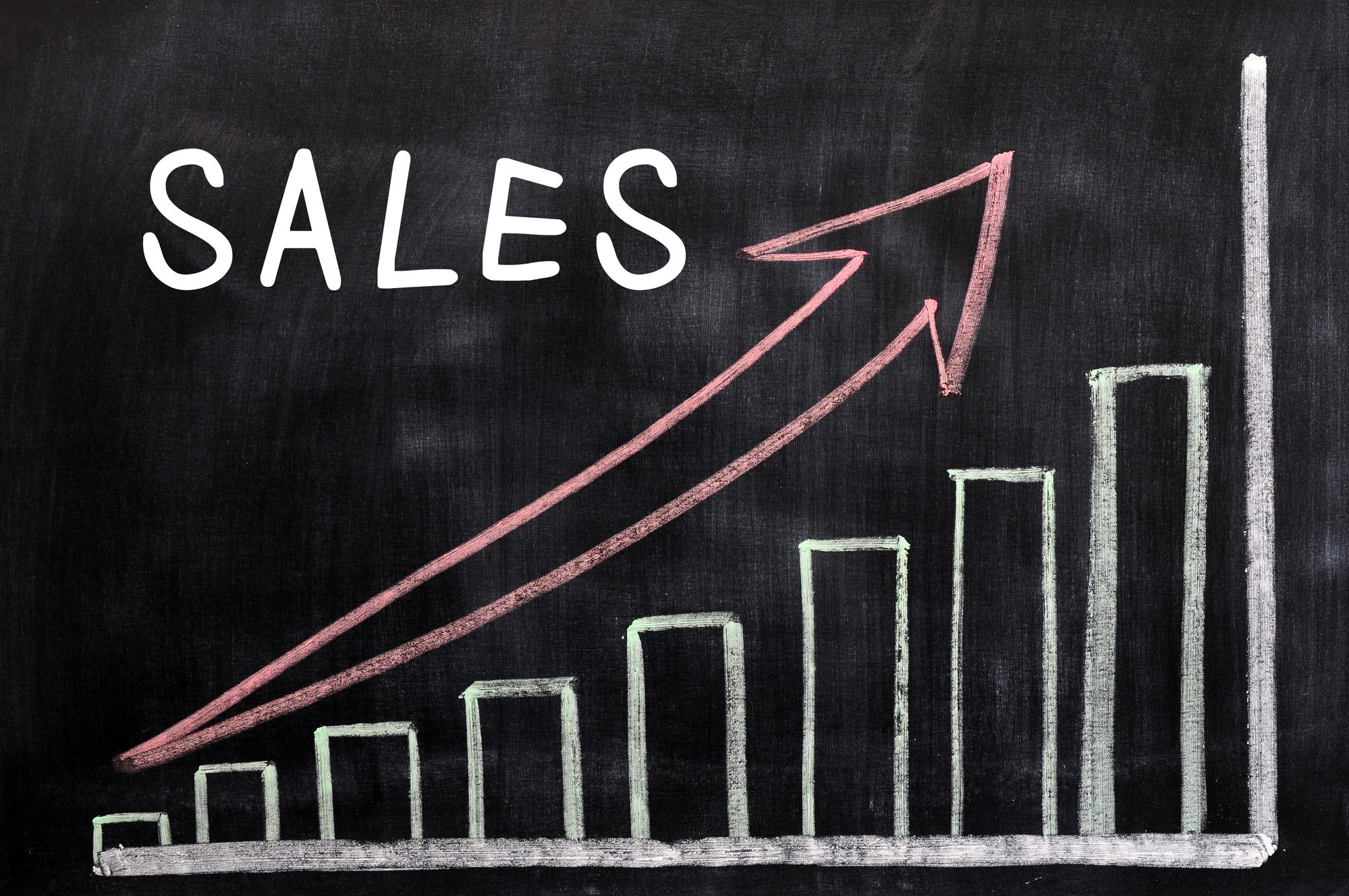 Sales graph on a blackboard with an arrow pointing up.