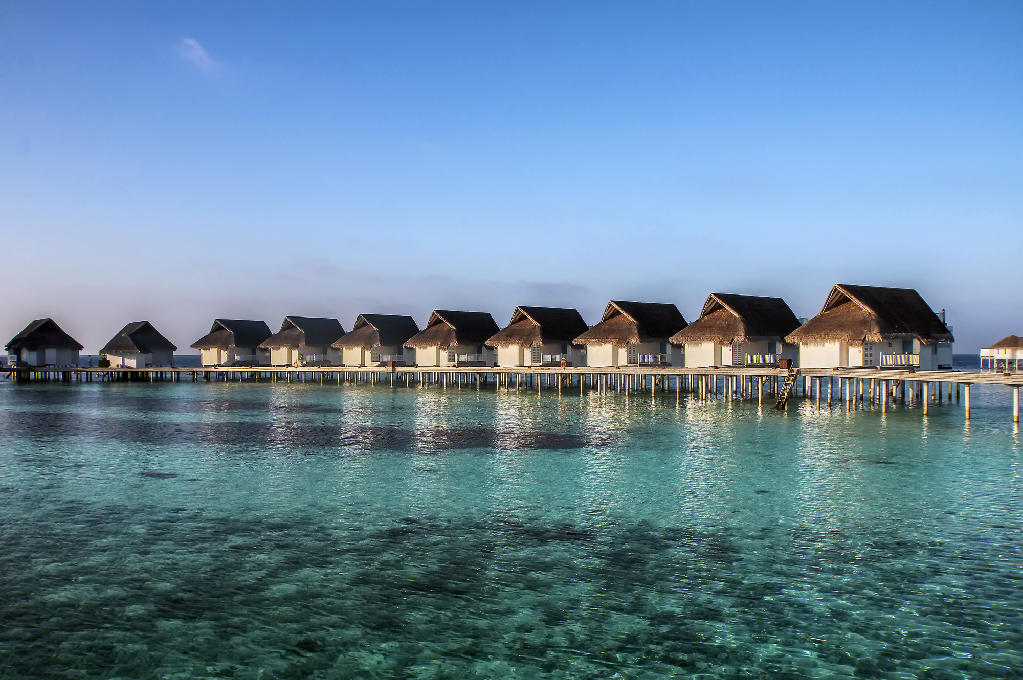 A row of wooden huts in the water.