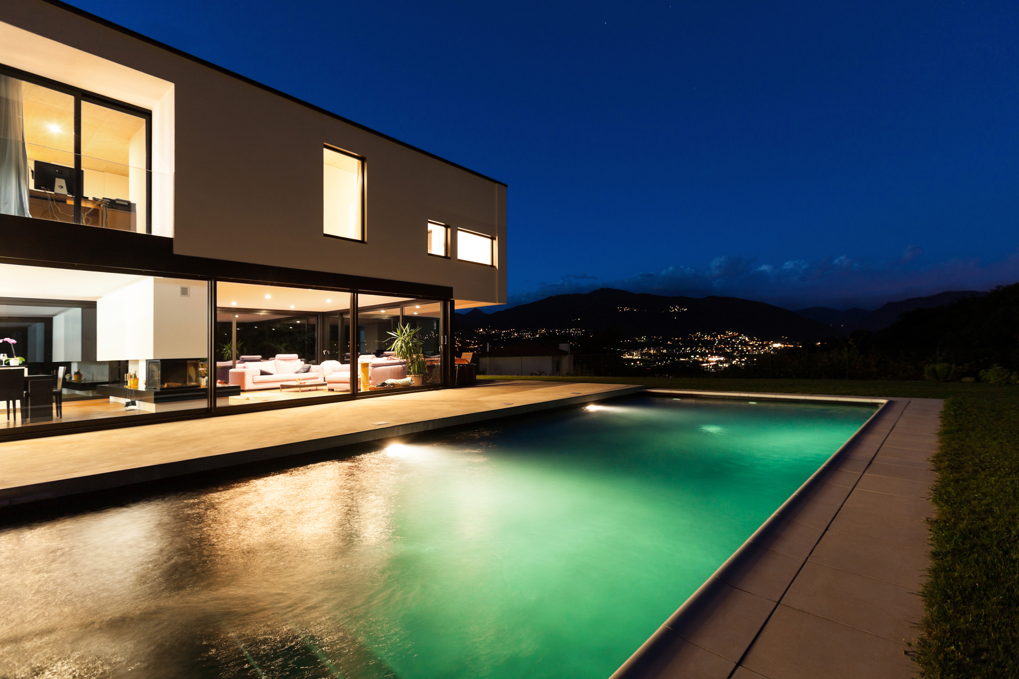 A house with a pool at night.