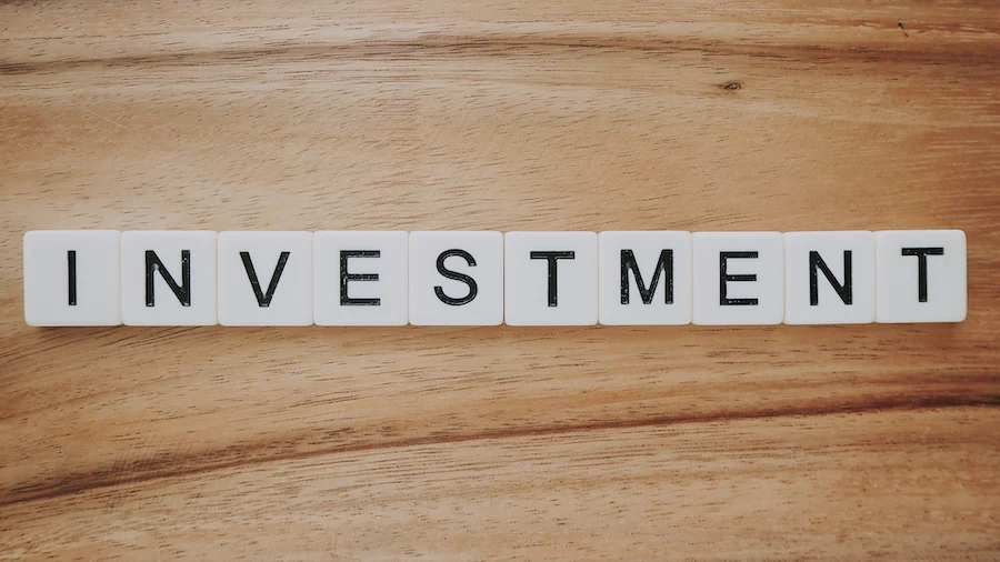 The word investment spelled out on a wooden table.