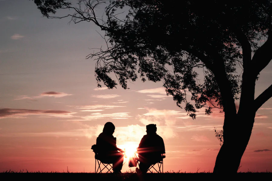retired couple lounging in chairs watching the sunset