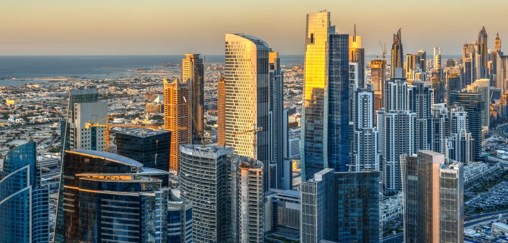 The real estate market of Dubai showcases its stunning skyline at sunset.