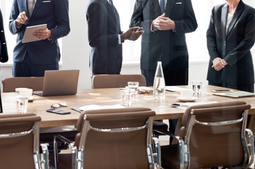A group of business people standing around a conference table.