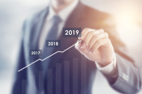 A businessman drawing a graph with the year 2019.