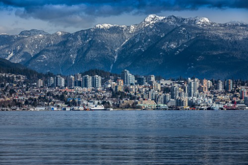 The city of vancouver with mountains in the background.
