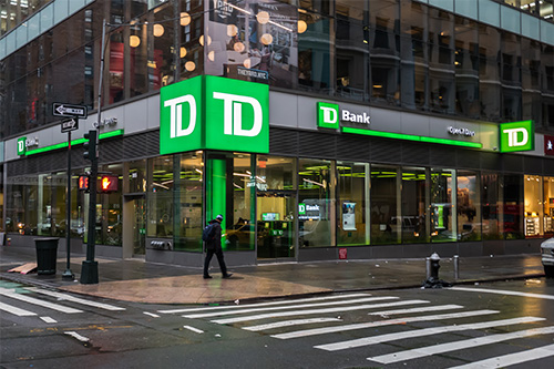 A green and white dd bank building on a rainy day.