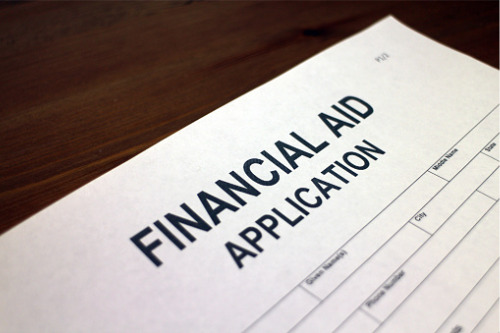 A financial aid application is sitting on top of a wooden table.