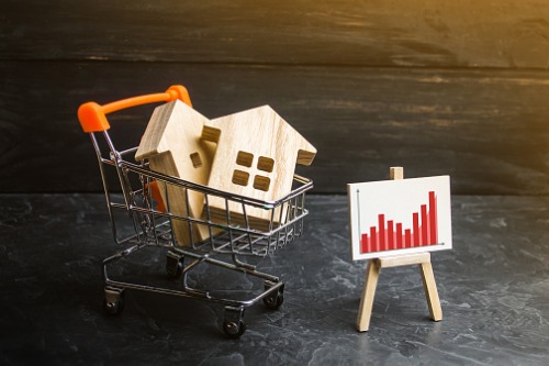 A shopping cart with a house and a graph on it.
