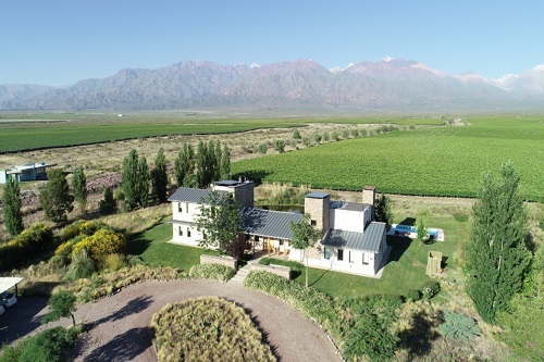 An aerial view of a house with mountains in the background.