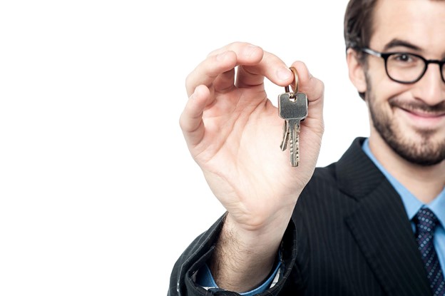 A man holding a key to a house.