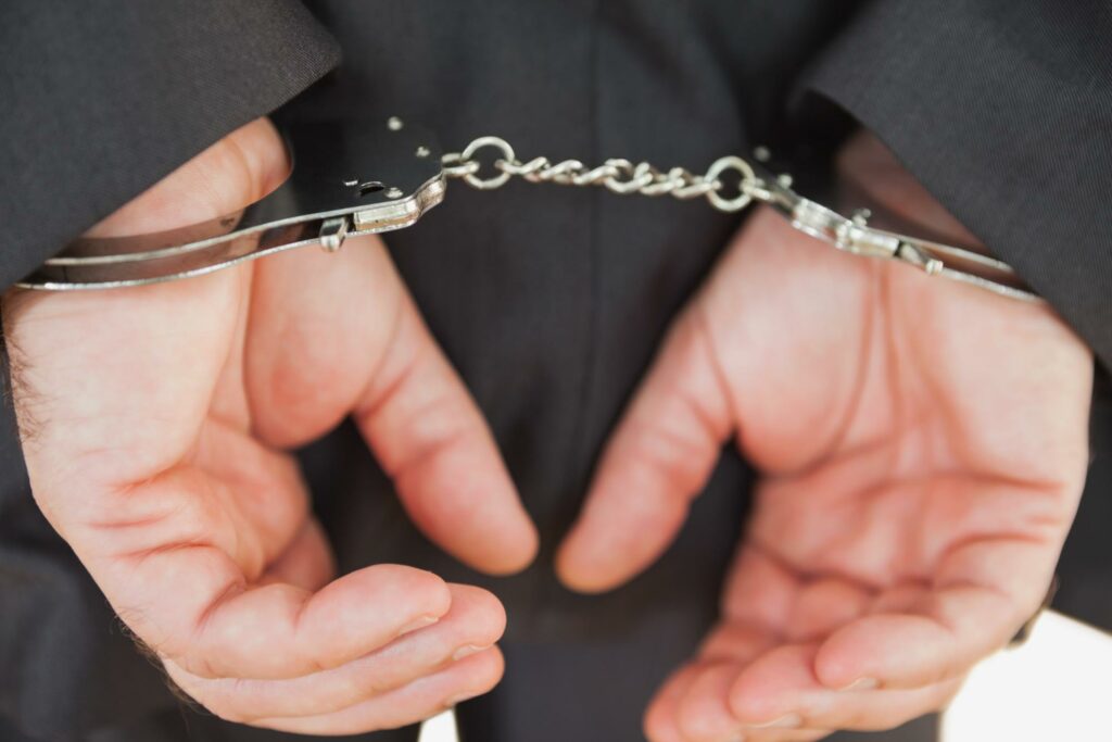 Handcuffs on a businessman's hands.