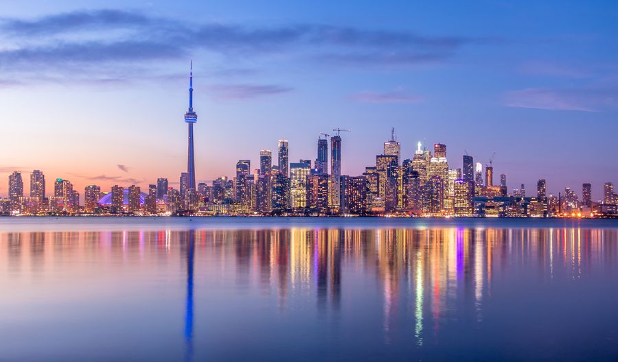Toronto skyline reflected in the water at dusk.