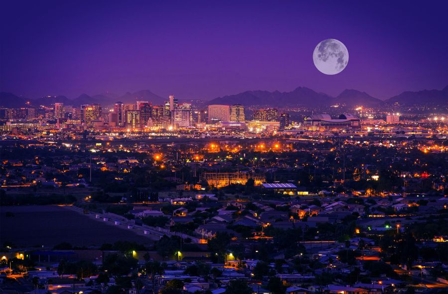 Phoenix skyline at night with a full moon.
