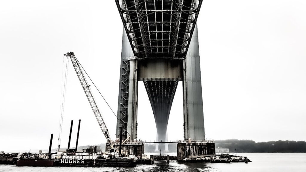 A black and white photo of a bridge under construction.