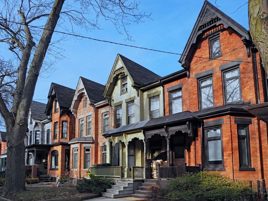 A row of victorian style houses on a street.