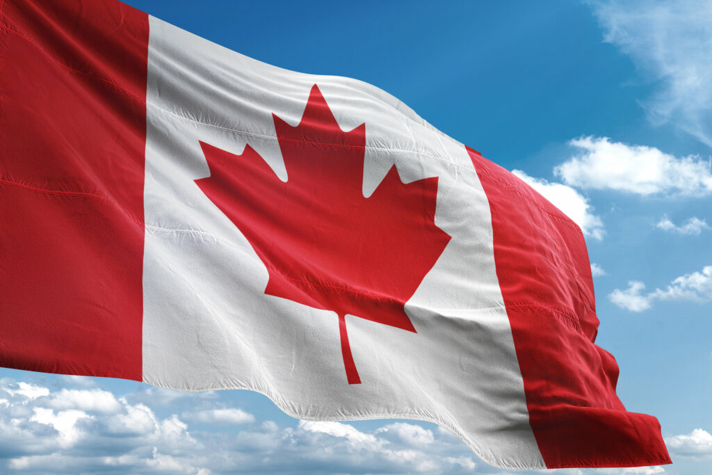 A canadian flag waving in the wind.