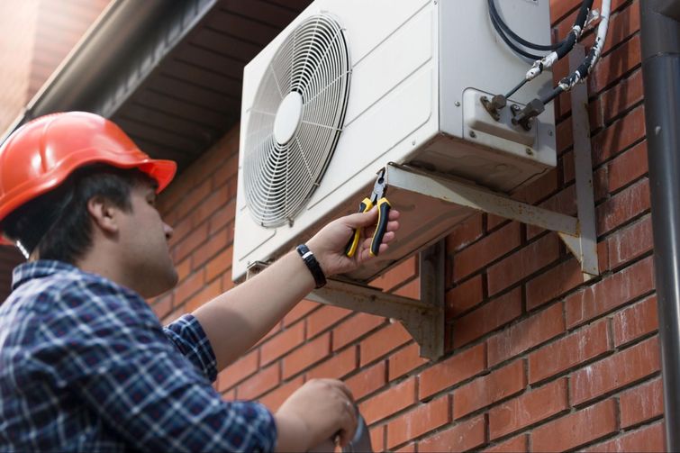 technician installing AC unit for tenant
