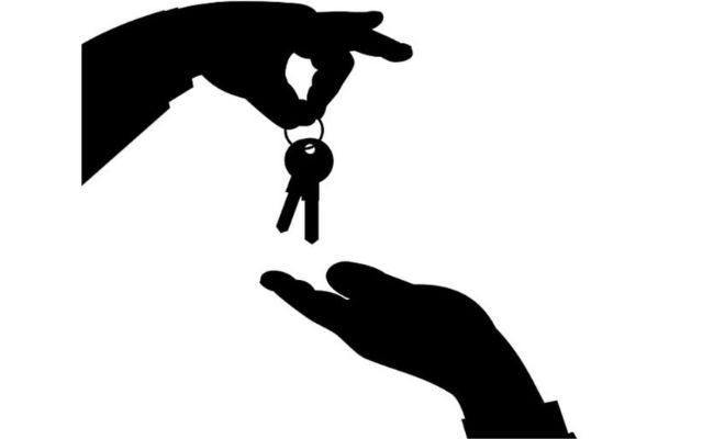A silhouette of a hand giving a key to another person.