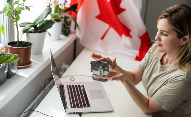 A woman is looking at a picture of a canadian flag on her laptop.