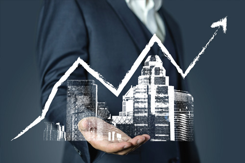 A businessman holding a hand with a graph showing the growth of a city.