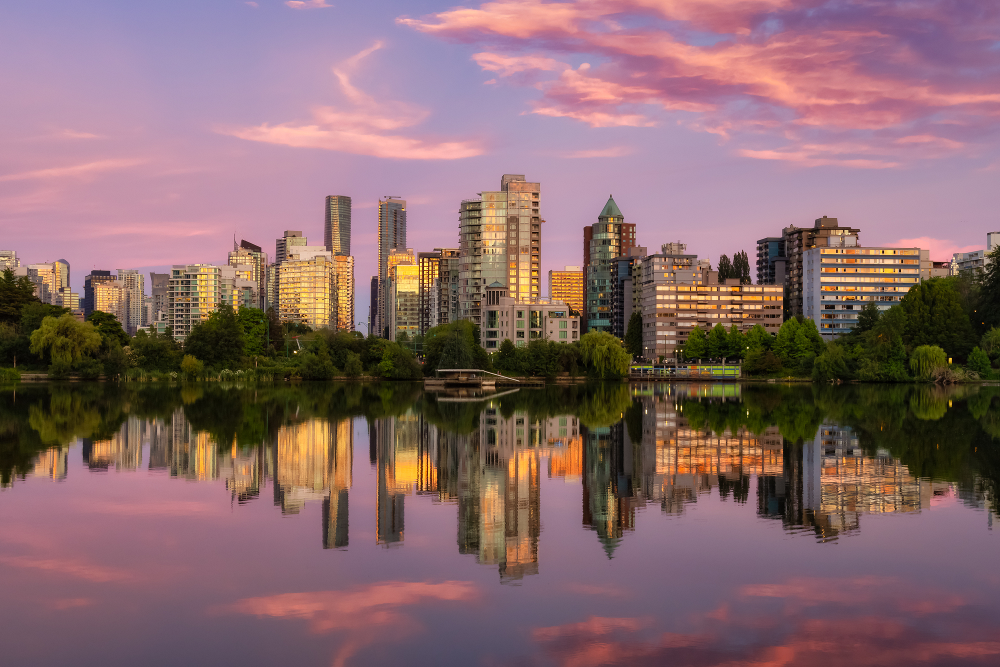 View of Lost Lagoon in famous Stanley Park in a modern city with buildings skyline