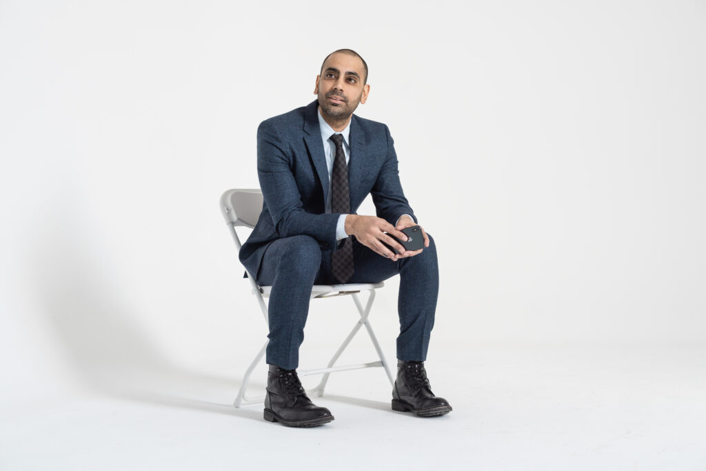 A man in a suit sitting on a chair.
