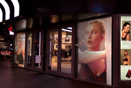 An advertisement for a clothing store is displayed on a storefront.
