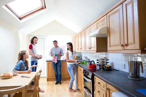 A group of people in a kitchen with a skylight.
