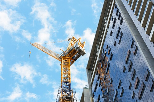 A construction crane is on top of a building.