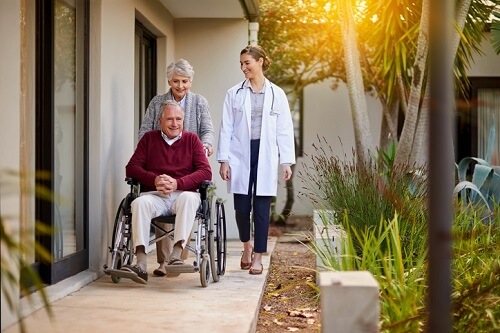 An elderly couple in a wheelchair and a doctor in a wheelchair.