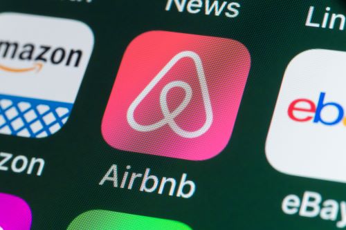 The airbnb logo is displayed on an iphone.