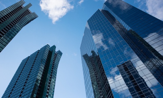 A group of tall glass buildings against a blue sky.