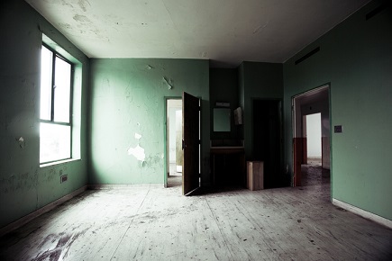An empty room with green walls and a window.
