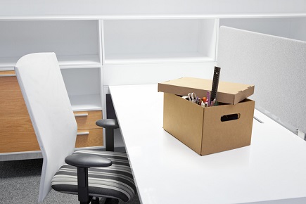 An office desk with a box on it and a chair.