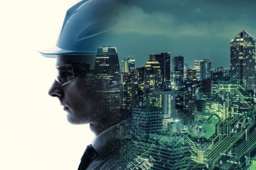 A man in a hard hat is standing in front of a cityscape.