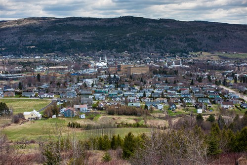 A view of a small town with mountains in the background.