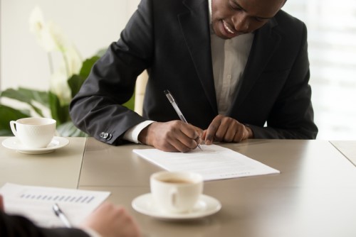 A businessman signing a contract at a table.