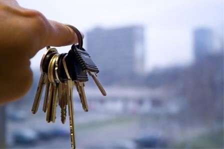 A person holding a bunch of keys in front of a window.