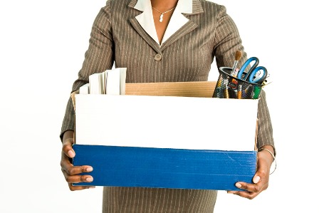 A woman in a business suit holding a box full of supplies.