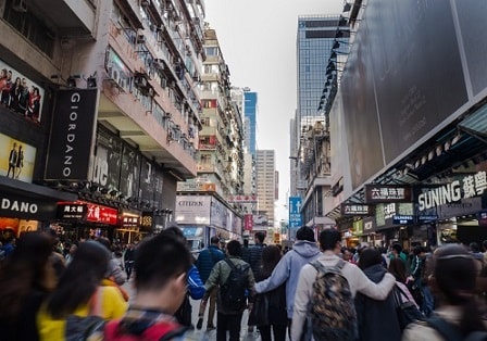 A crowd of people walking down a busy street in hong kong.