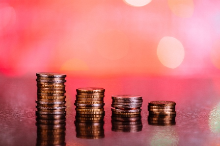 Stacks of coins in front of a red background.