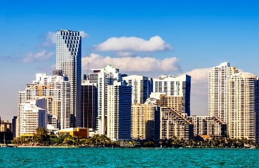 The skyline of miami, florida is seen from the water.