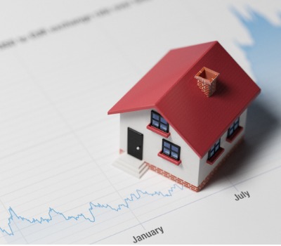 A house model on top of a stock chart.
