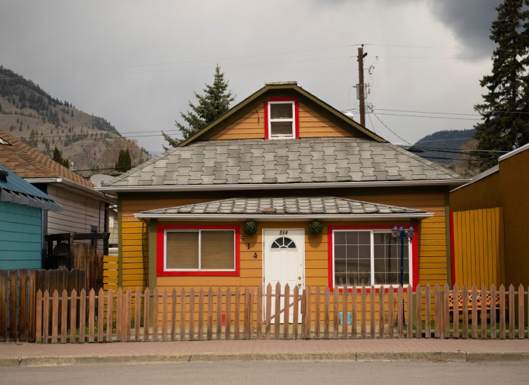A yellow house with red trim, perfect for tiny homes enthusiasts.