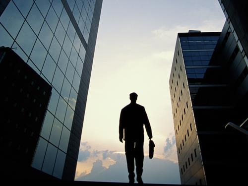 Silhouette of a businessman walking down the steps of a building.