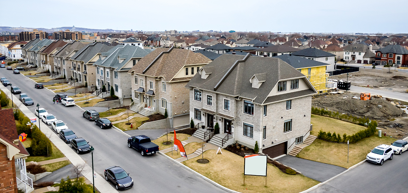 An aerial view of a street with houses in the background.