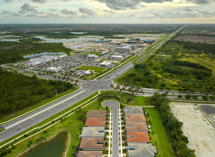 A stunning aerial view showcasing the real estate potential and convenient highway access of a residential area.