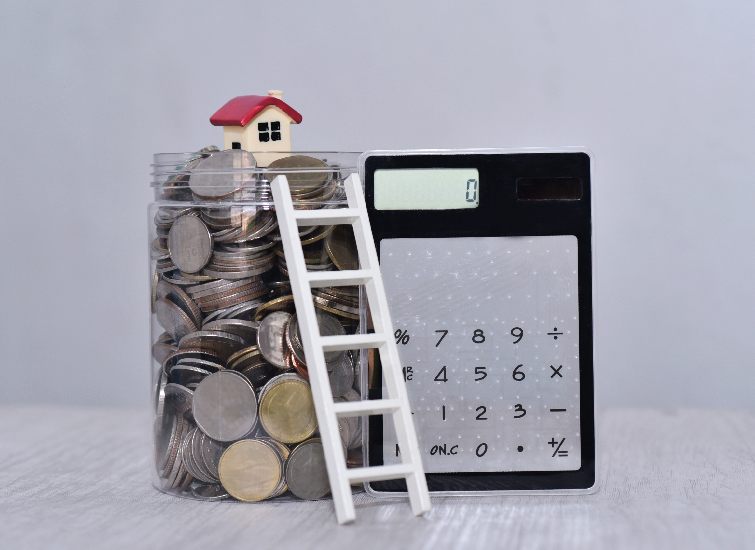 A jar filled with coins sits on a table alongside a ladder, inviting consideration for the potential yield calculation.