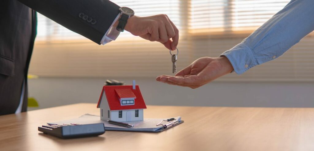 Two people handing over keys to a rental property.